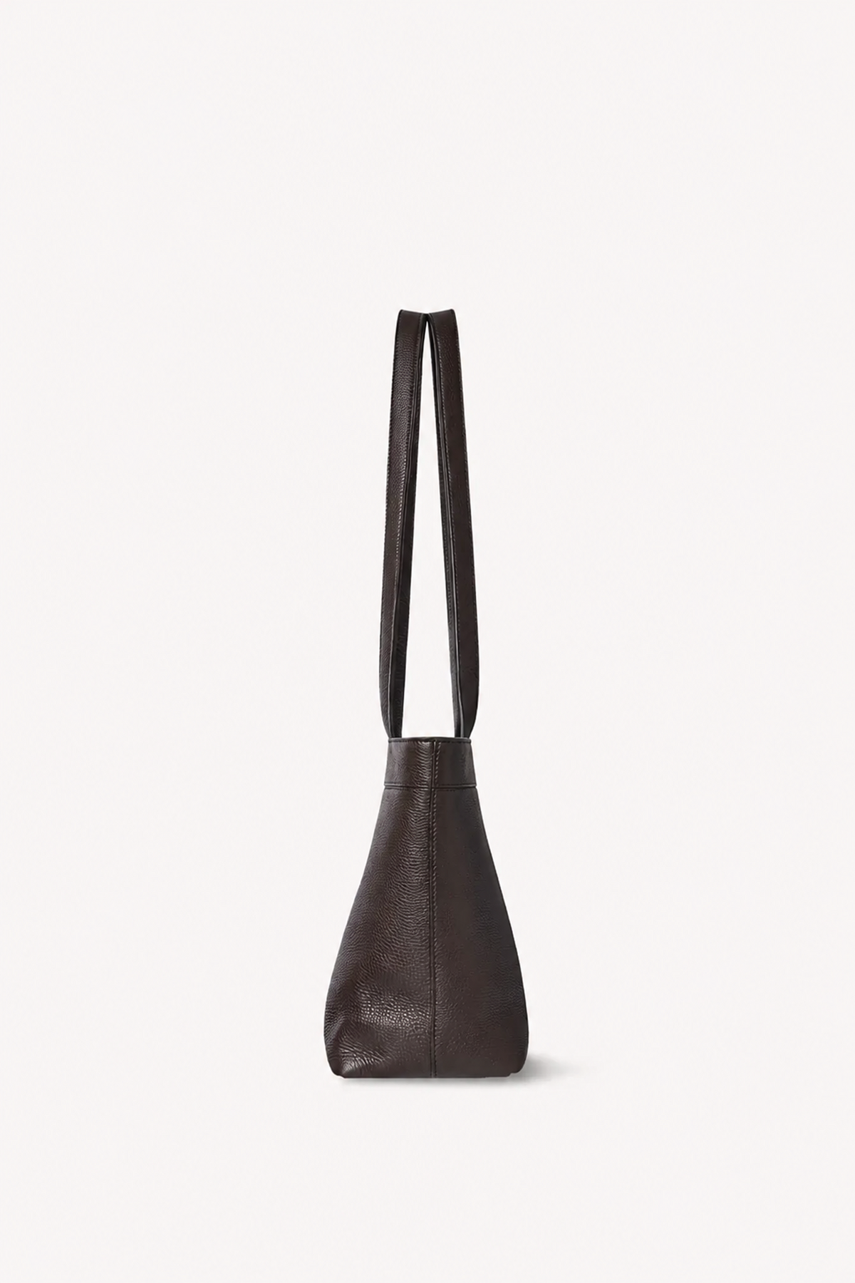 A dark brown leather tote bag with two long shoulder straps, shown from a side profile against a clean, off-white background.